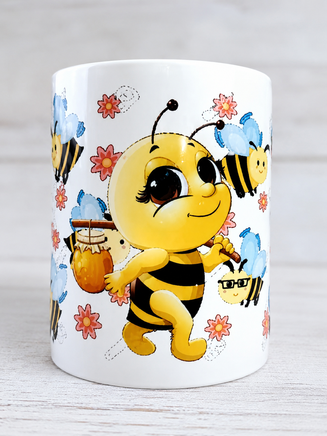 Taza con abejita kawaii sosteniendo tarro de miel rodeada de flores